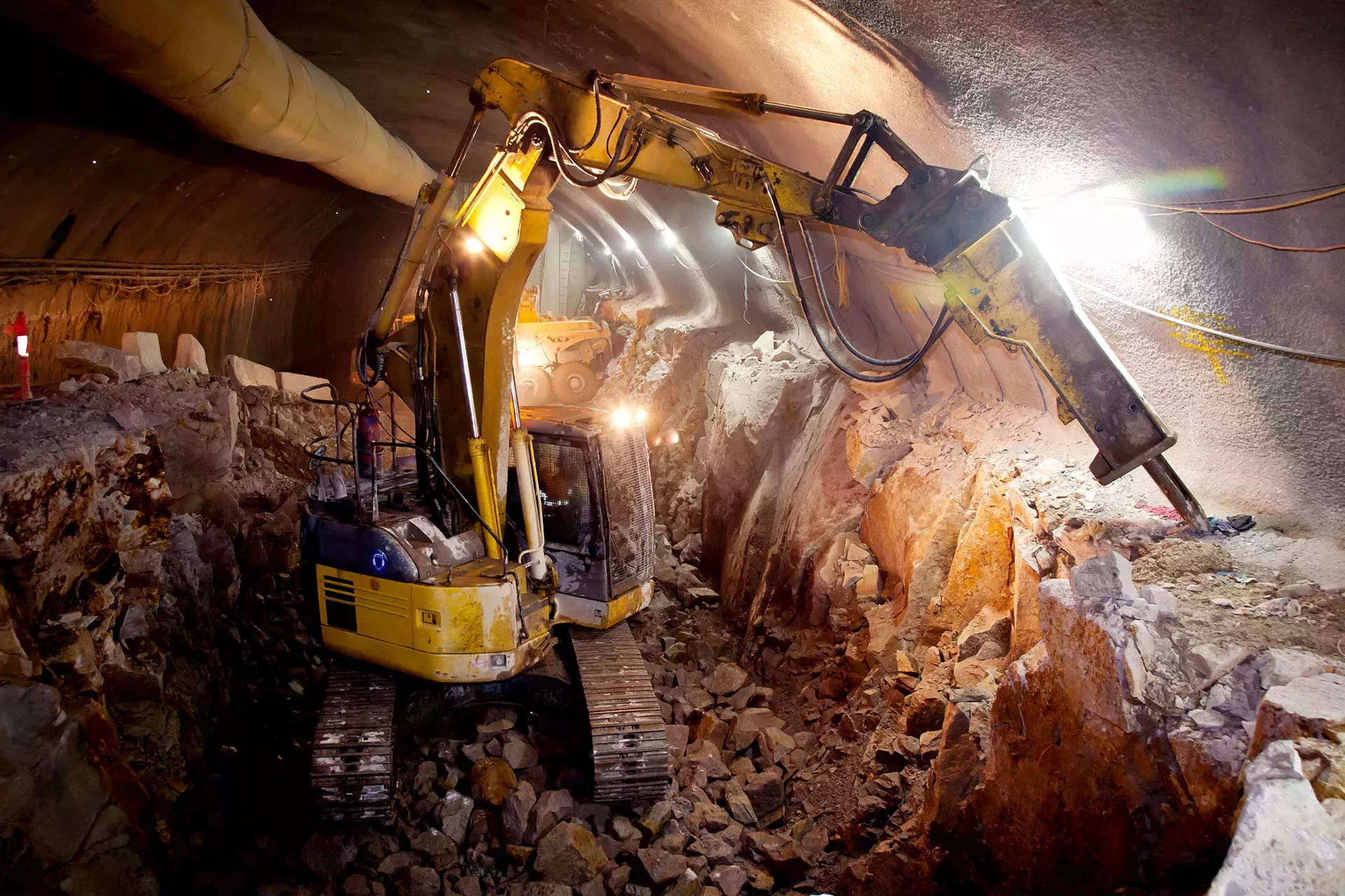 Gelber Bagger mit Presslufthammer in einem Tunnel