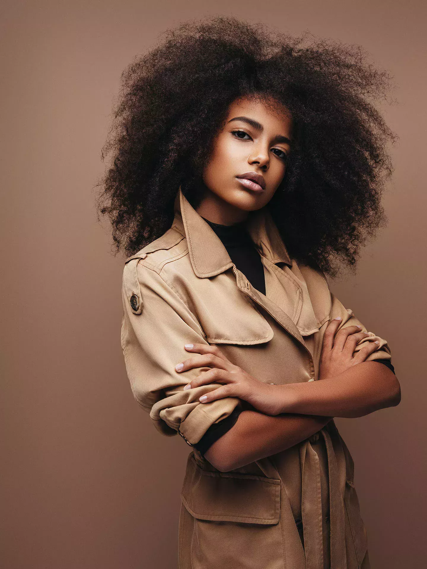 Woman with curls in a beige parker